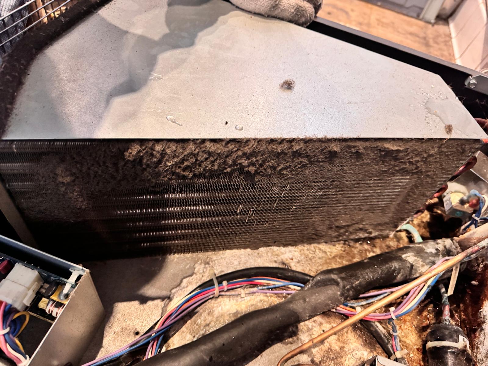 Dust-clogged condenser coil on commercial refrigeration equipment